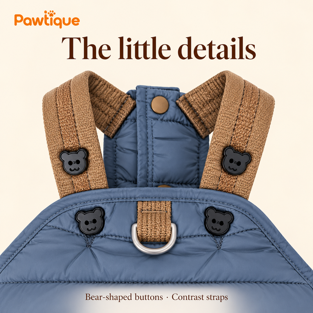 Close-up of bear-shaped buttons, brown shoulder straps and metal D-ring on the blue jumpsuit