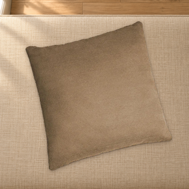 Brown herringbone chenille pillow styling reference resting on a fabric-covered bench