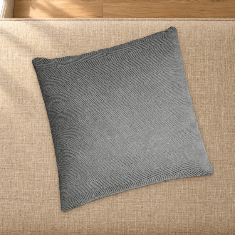 Grey herringbone chenille pillow styling reference resting on a fabric-covered bench