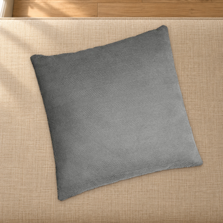 Grey herringbone chenille pillow styling reference resting on a fabric-covered bench