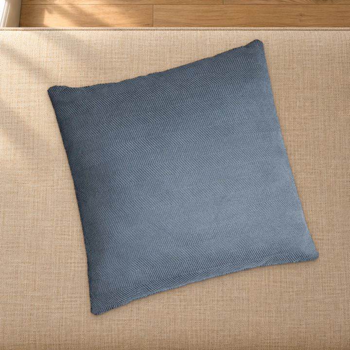 Greyish Blue herringbone chenille pillow styling reference resting on a fabric-covered bench