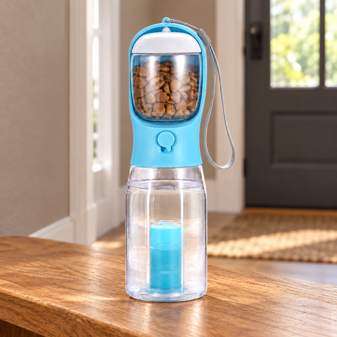 Blue 3-in-1 portable pet water bottle with its wrist loop and separate compartments on an oak entryway bench.