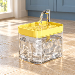 Yellow AquaArc fountain in a naturally lit home setting, with its original tank, top tray and outlet configuration.