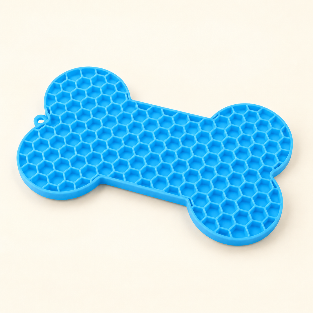 Blue bone-shaped lick mat with a honeycomb front surface on a warm cream background
