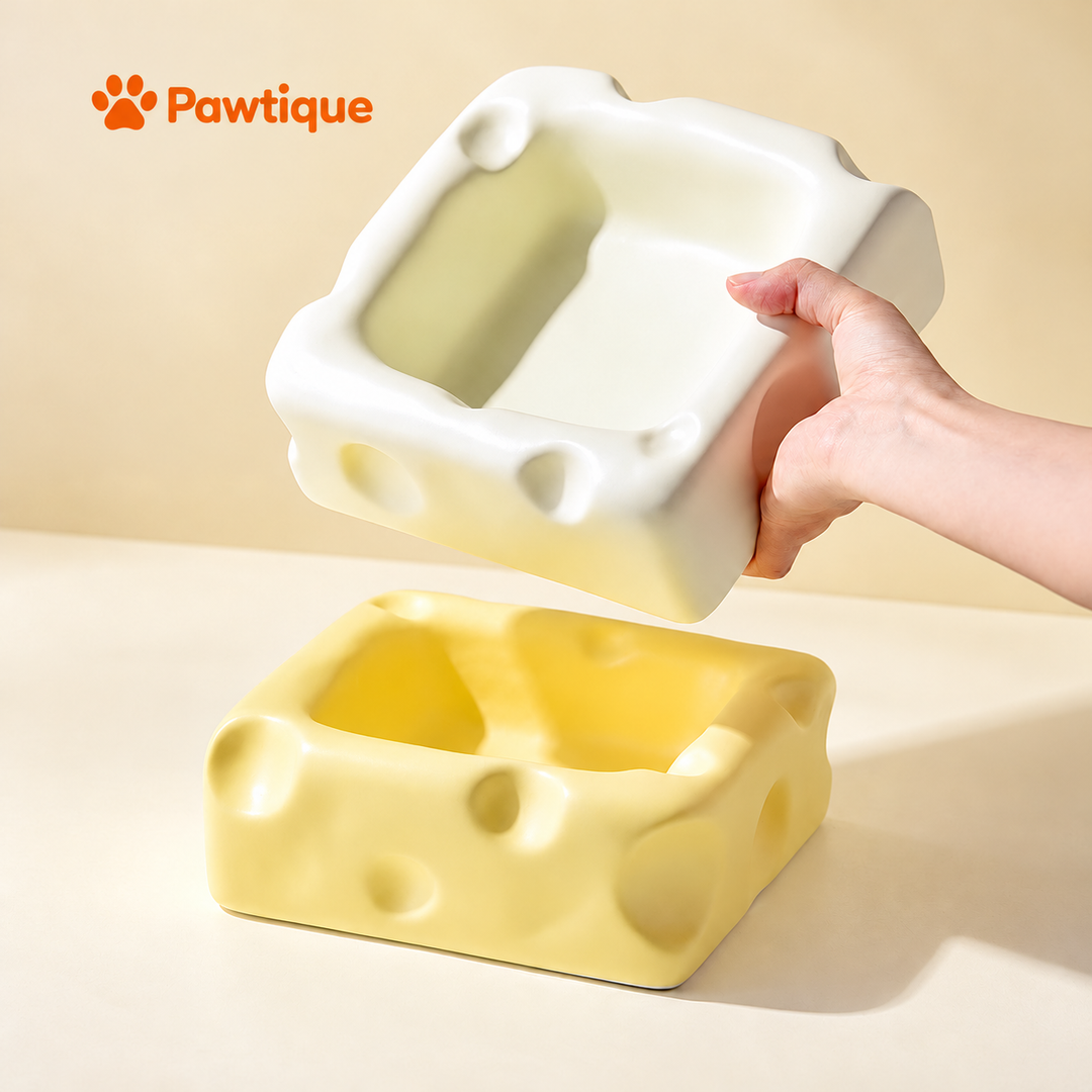White cheese-shaped ceramic bowl held in one hand above a yellow bowl