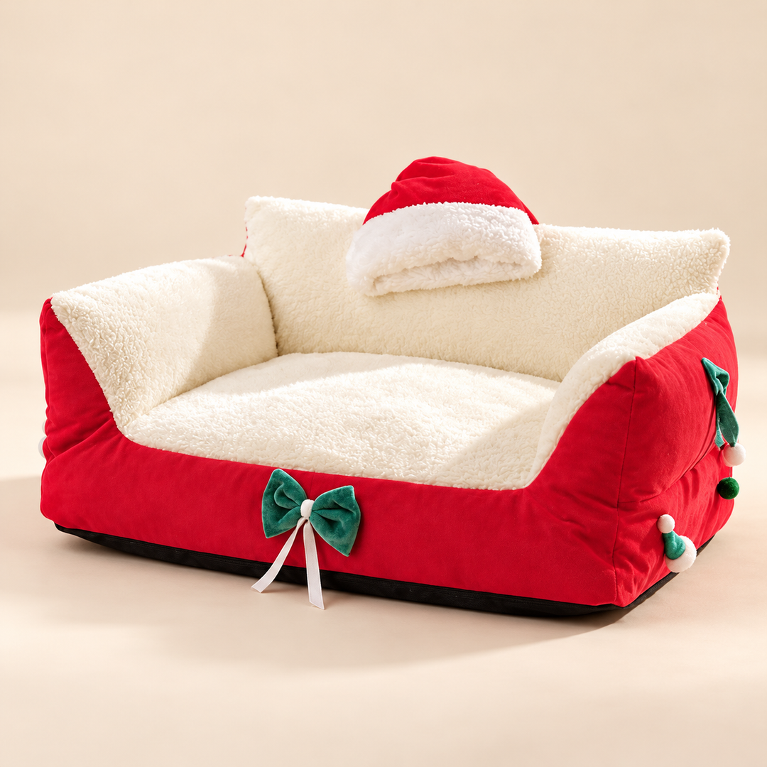 Red Christmas bow pet sofa bed with white plush seat and festive decorations on a cream background