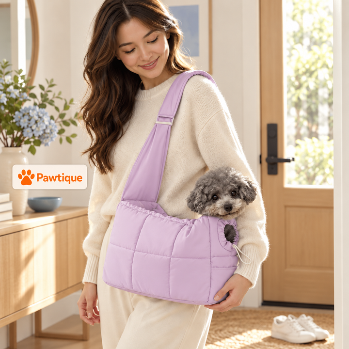 Purple CloudCarry quilted pet sling worn indoors with a small grey dog and a hand supporting the pouch
