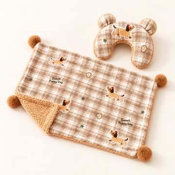 CloudNest plaid pet blanket with a caramel reverse and four corner pom-poms beside its matching U-shaped pillow.