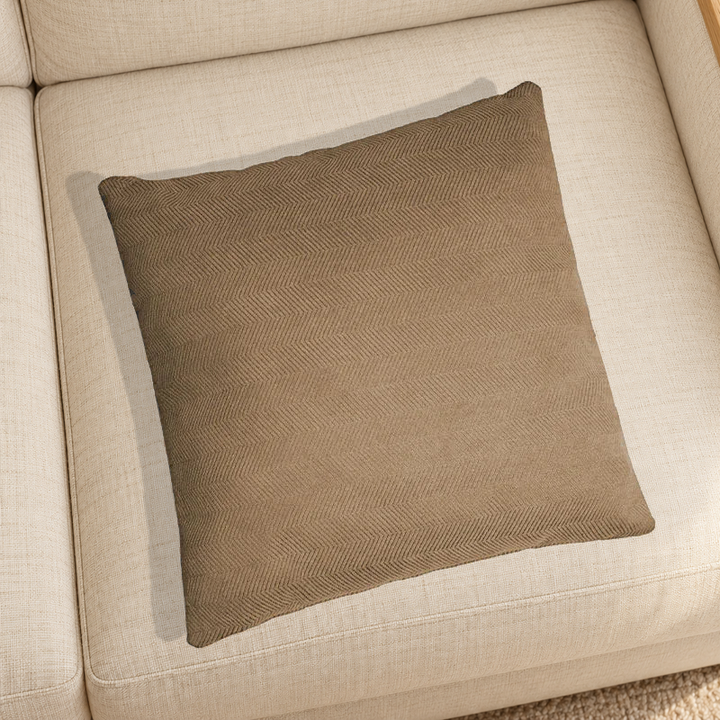 Brown herringbone chenille pillow resting on a linen chair in a home setting; one selected-color pillow option.