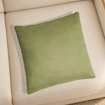 Green herringbone chenille pillow resting on a linen chair in a home setting; one selected-color pillow option.