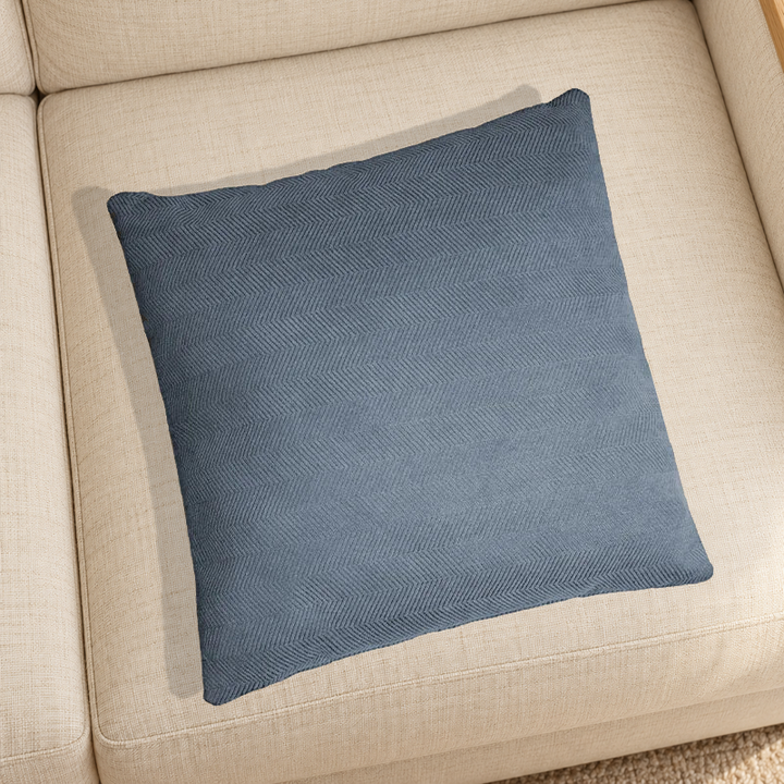 Greyish Blue herringbone chenille pillow resting on a linen chair in a home setting; one selected-color pillow option.