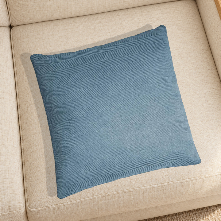 Lake Blue herringbone chenille pillow resting on a linen chair in a home setting; one selected-color pillow option.