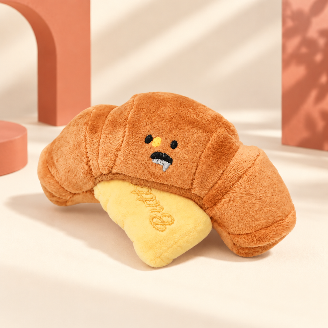 One ButterCroissant plush dog toy with embroidered face and butter piece on a clean backdrop