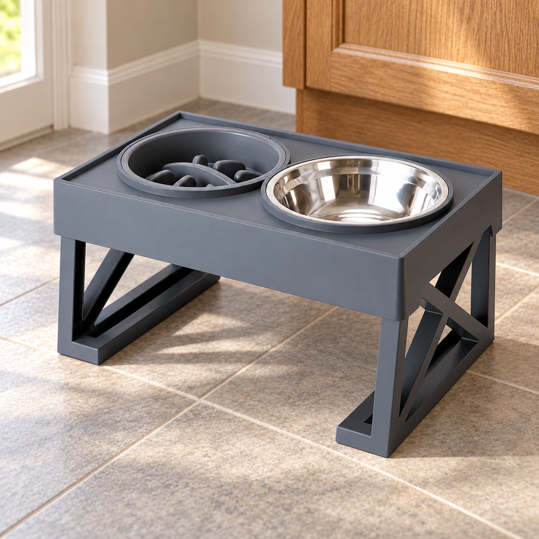 Gray elevated stand with a dark slow-feeder bowl on the left and stainless steel bowl on the right, shown on a tiled kitchen floor.