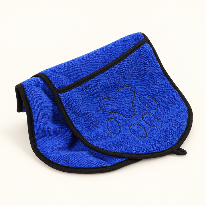 Dark blue microfiber pet drying towel folded to show its rounded hand pocket, black binding and paw embroidery