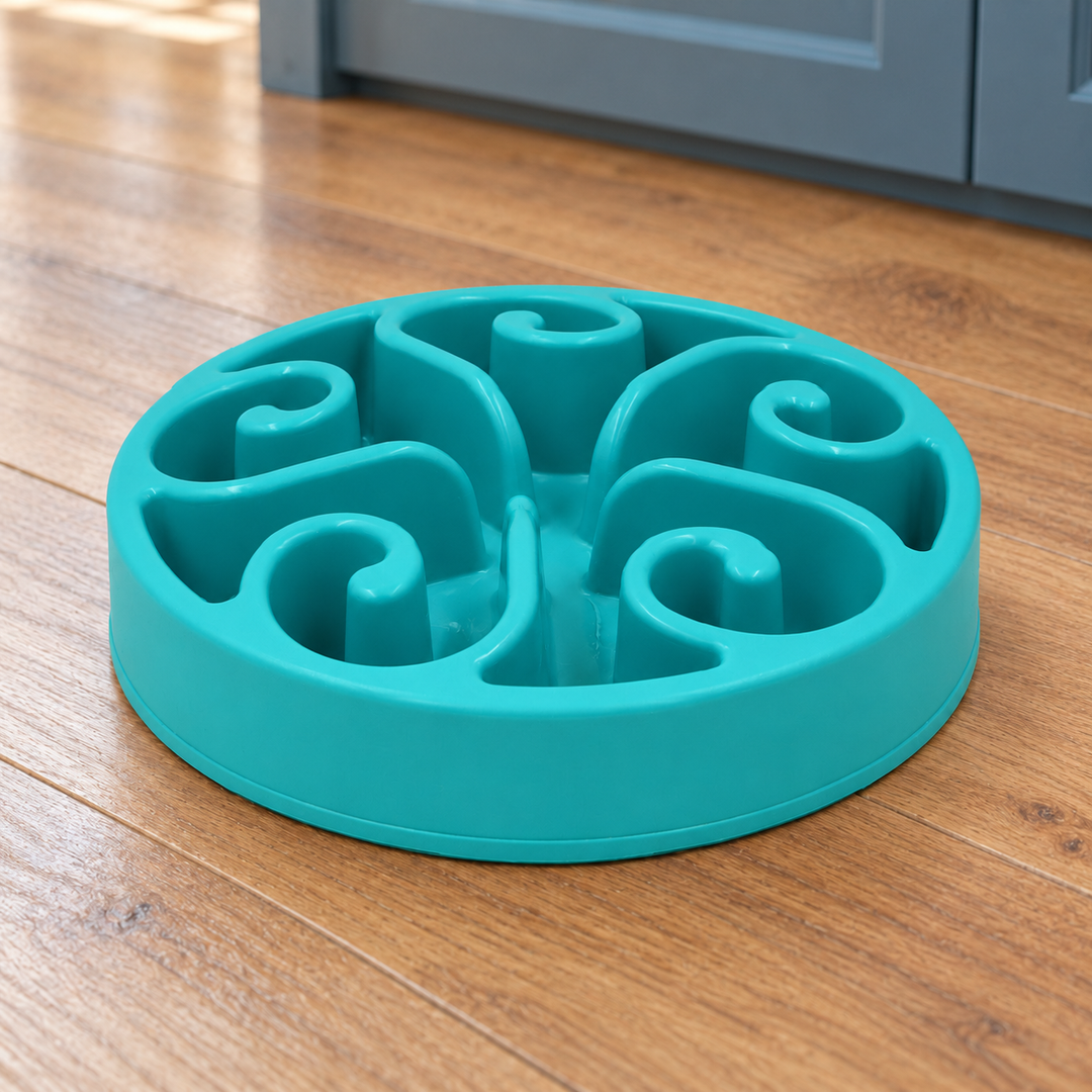 Lake Blue slow-feeder dog bowl with five spiral channels on a natural wood kitchen floor.