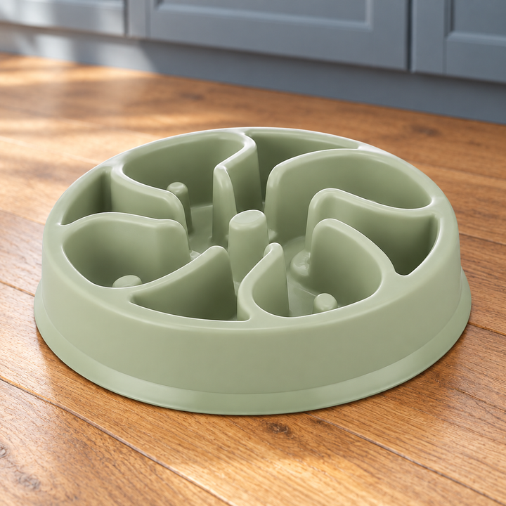 Sage Green slow-feeder dog bowl with broad curved divider walls and distinct raised posts on a natural wood kitchen floor.