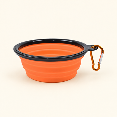 Orange collapsible silicone dog travel bowl with black rim and attached orange-gold clip