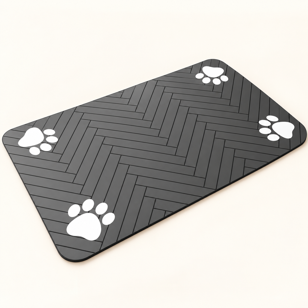 Flat dark-gray pet feeding mat with rounded corners, black herringbone lines and four white paw motifs.