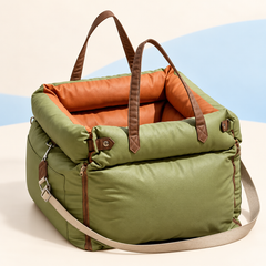 Olive Green RoadNest padded car seat and carrier with orange lining, brown handles and detachable beige shoulder strap
