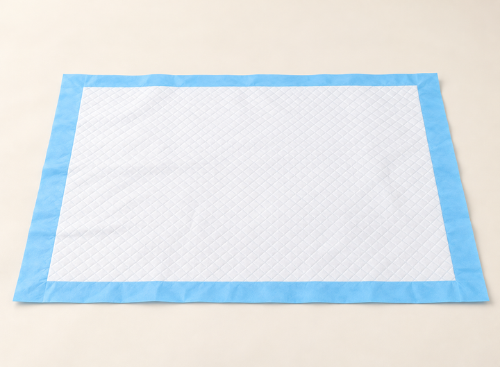 Rectangular disposable training pad with a white quilted surface and flat blue border