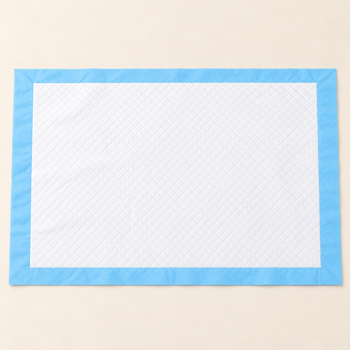 Wide rectangular disposable training pad with white quilted surface and flat blue border
