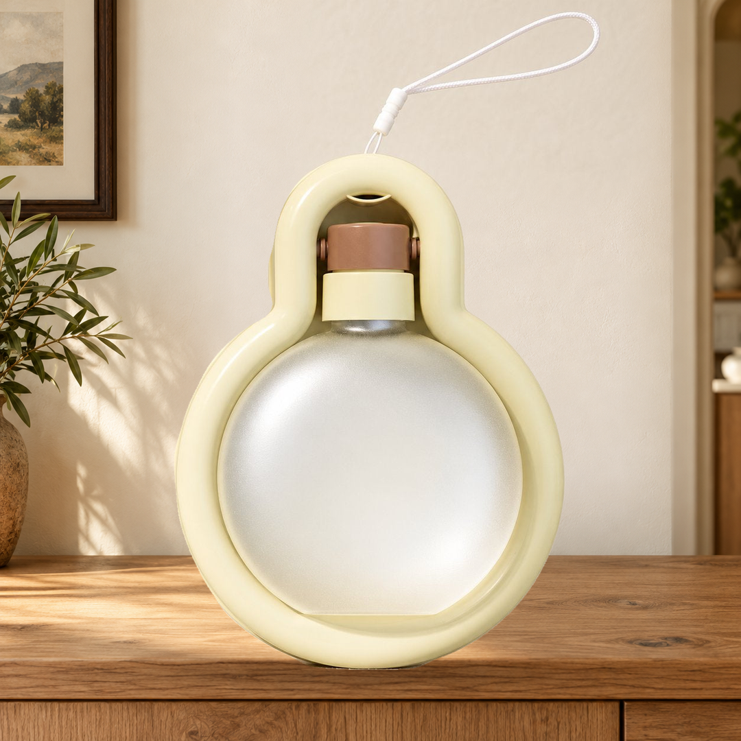 Beige Large travel water bottle folded into its tray, with original carry loop, on a warm home console.