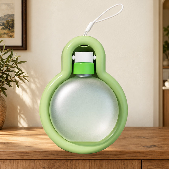 Green Large travel water bottle folded into its tray, with original carry loop, on a warm home console.