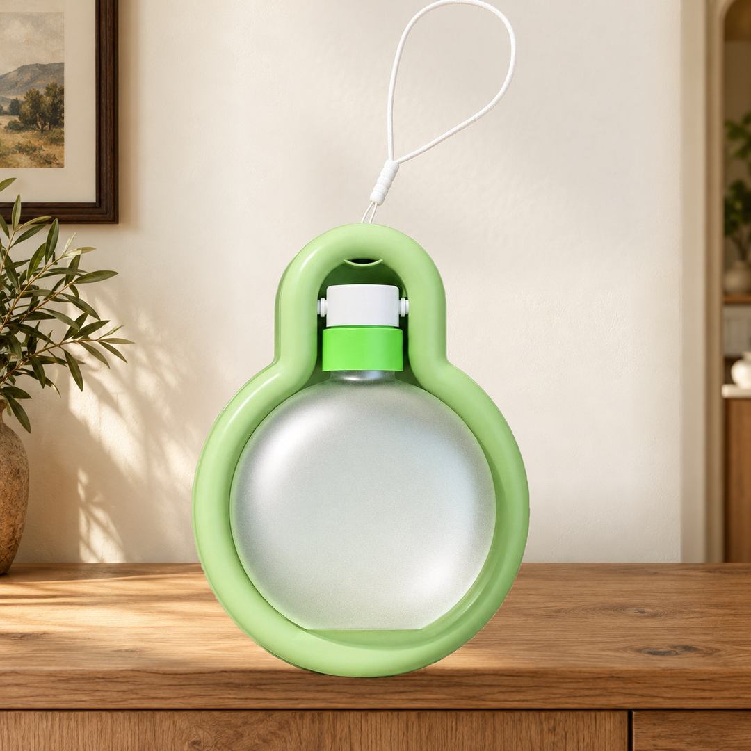 Green Small travel water bottle folded into its tray, with original carry loop, on a warm home console.