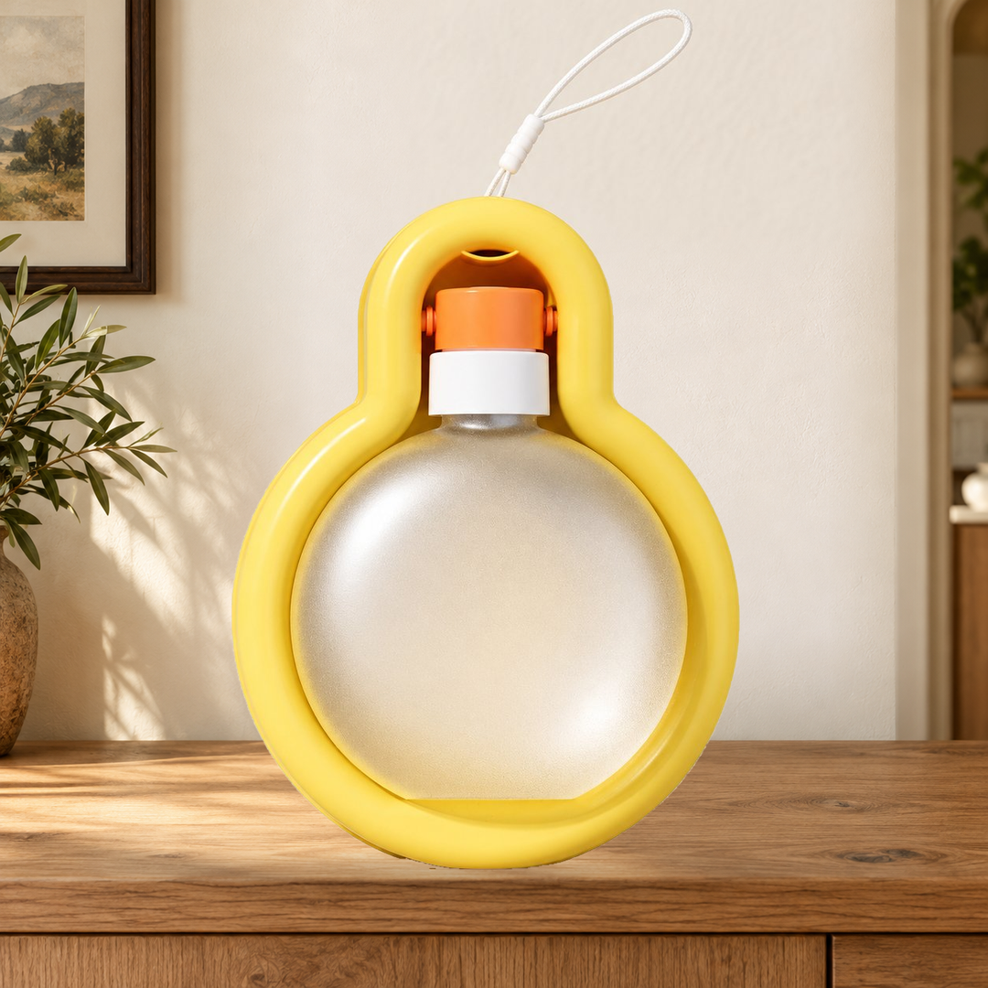 Yellow Large travel water bottle folded into its tray, with original carry loop, on a warm home console.
