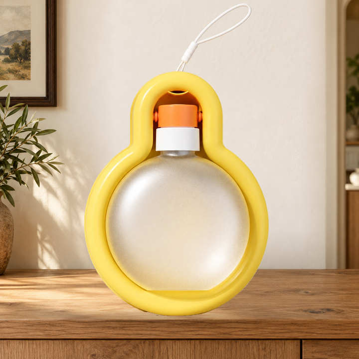 Yellow Large travel water bottle folded into its tray, with original carry loop, on a warm home console.