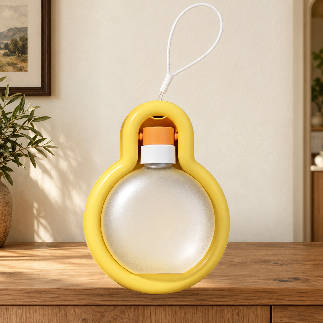 Yellow Small travel water bottle folded into its tray, with original carry loop, on a warm home console.
