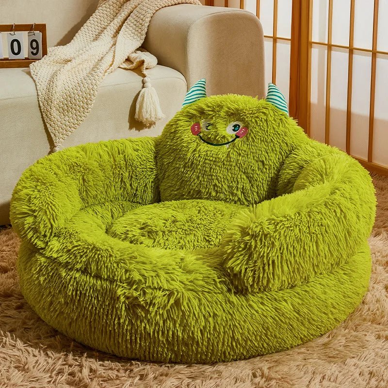 Empty green monster bed showing the rounded rim, shaggy center, stitched face and striped horns.